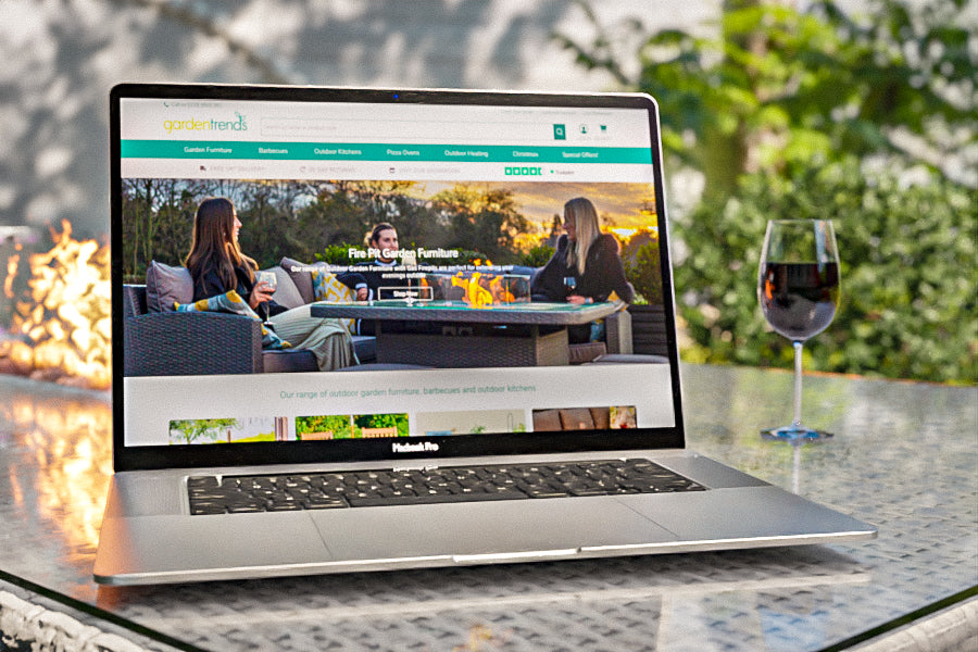 Dakota Firepit Table with Macbook Pro and the Garden Trends website